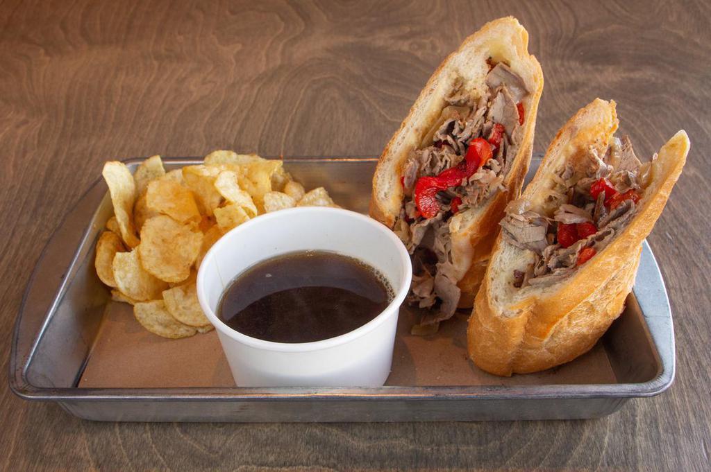 Tri Tip French Dip · Shaved roasted Tri Tip with grilled onions,  peppers, S & P aioli and melted provolone on a toasted baguette. Served with black pepper aus jus. 
