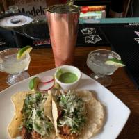 Tacos al Pastor · 2 tacos with marinated pork in a chile pineapple sauce. Topped with cilantro, onion, and sal...