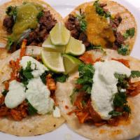 Tacos de Res/Steak Tacos  · Three steak tacos served with cilantro and onion with salsa verde on the side 