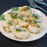 Dahi Puri · Wheat puffs filled with lentils, potatoes and topped with yogurt, chili, tamarind chutney an...