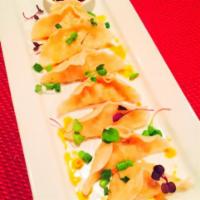 Steamed Pot Stickers · Minced chicken & vegetables wrapped and steamed served in a house made sauce, topped with fr...