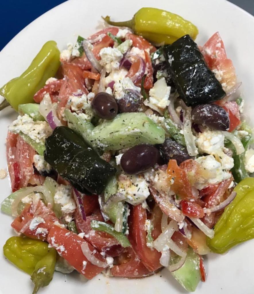 Horiatiki (Greek Salad) · Vine ripe beef steak tomatoes, onions, cucumbers, peppers, feta cheese, olives, oregano and olive oil. 