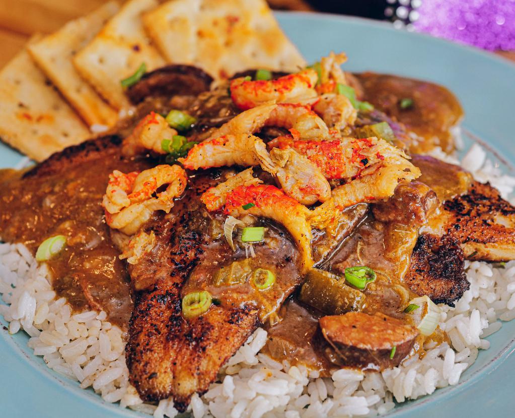 Catfish Tout · 2 blackened fillets on a bed of white rice, smothered with a mixture of gumbo, etouffee and crawfish.