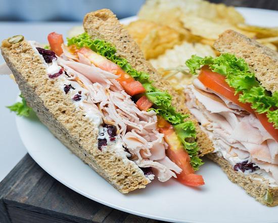 Cranky Turkey Sandwich · Turkey, cream cheese, dried cranberries, lettuce, tomato, red onion and mayo.