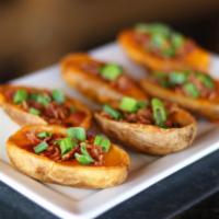 Potato Skins · 6 potato skins with melted cheddar cheese, bacon and chives.