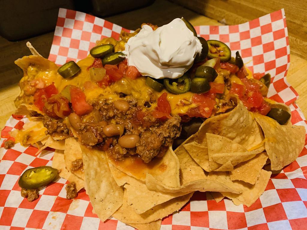 Red Douglas Supreme Nachos · Our red chili added over fresh tortilla chips, topped with cheddar cheese, jalapenos, tomatoes and sour cream.