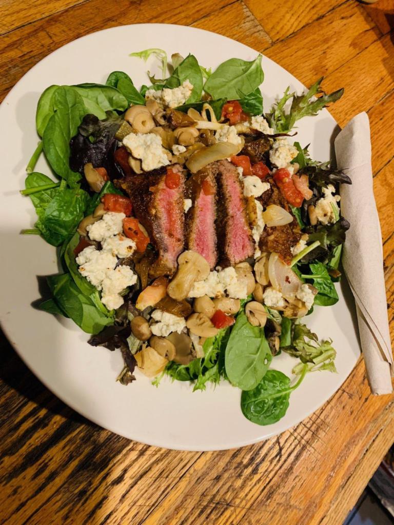 Black & Blue Steak Salad · Blackened seared Strip served on a bed of fresh baby spring mix with tomatoes, sauteed mushrooms, onions and blue cheese crumbles