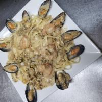 Fettuccine seafood pasta · Jumbo shrimps, scallops, calamari, baby clams, mussels and choice of red or white sauce .inc...