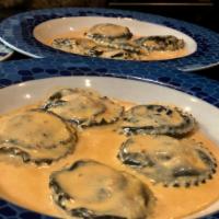 Agnolotti Neri all' Aragosta · Squid-ink round ravioli filled with lobster, served in a creamy brandy lobster sauce.
