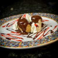 Profiteroles · Cream puffs filled with vanilla custard cream dressed in chocolate sauce.