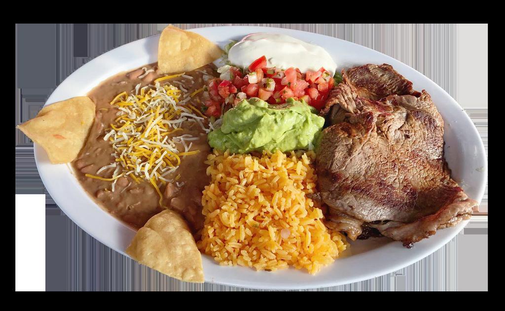 Asada Plate Combo · flat grill steak, serve with rice, refried beans garnished with cheese and tortilla chips, lettuce, guacamole, sour cream, pico de gallo, jalapeños, lime wedges and tortillas on the side