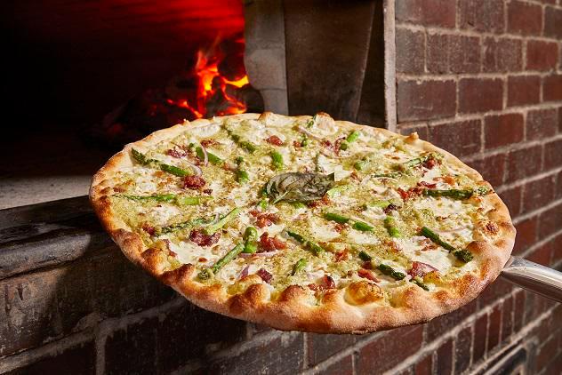 Bacon and Asparagus Pizza with Spicy Honey · Artichoke pesto pizza topped with asparagus, bacon and red onion, finished with
a drizzle of red-pepper-infused honey.
