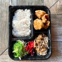 Chicken Karaage Bento Box · Fried chicken bites served with a side of beef sukiyaki, seaweed salad, radish and a bed of ...
