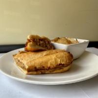 Mama's Cuban Sandwich · Slow roasted pork shoulder, ham, Mozzarella, Swiss cheese, sofrito sauce, pickles, dijon mus...