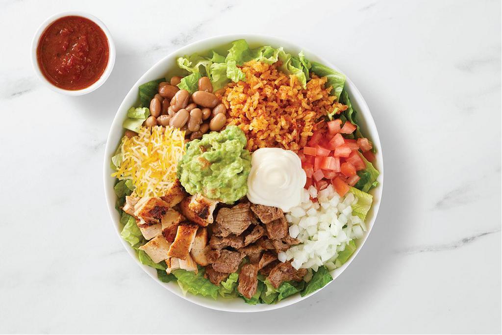 Godzilla Bowl · Steak & chicken, pinto beans, Spanish rice, guacamole, cheese, sour cream, onions, tomatoes, mild salsa, on a bed of lettuce
