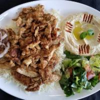 Chicken Shawarma Plate · Sliced chicken served on a bed of rice alongside a serving of house salad, hummus, and bread.