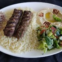 Lamb & Beef Kofta Plate · A skewer of lamb & beef kofta served on a bed of rice alongside a serving of house salad, hu...