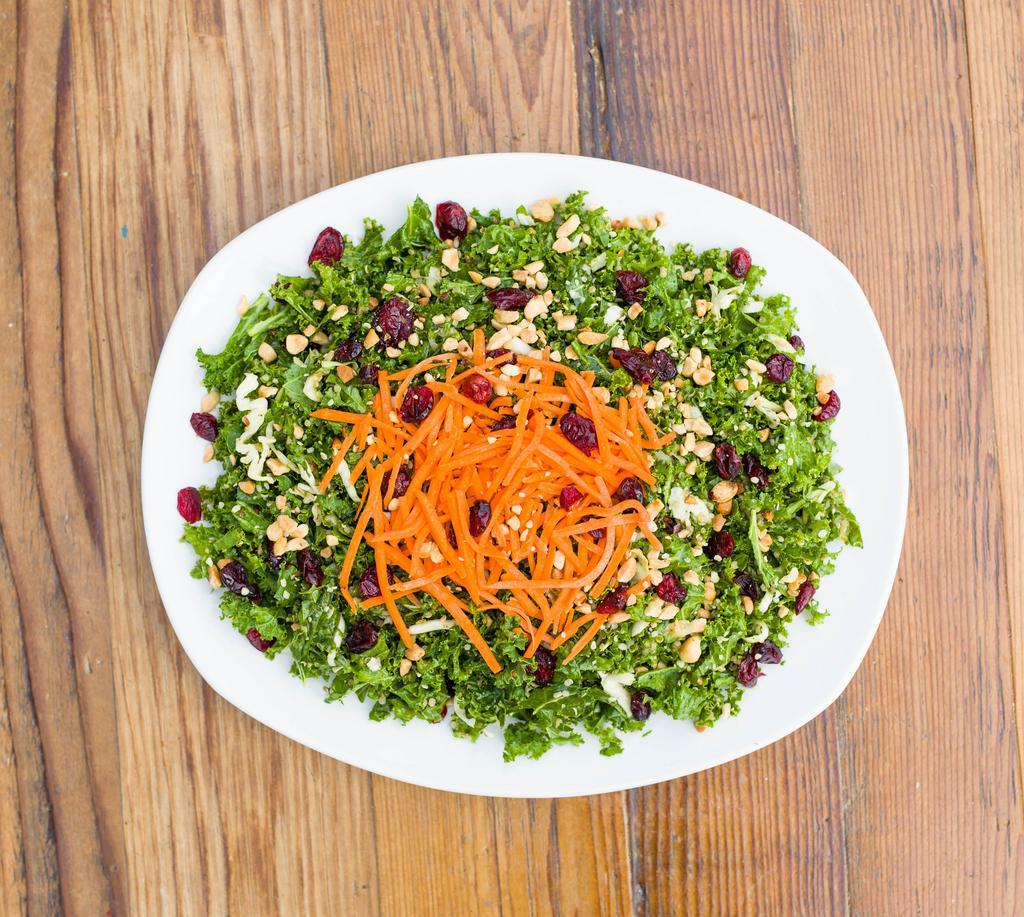 Kale Salad · Kale, cabbage, quinoa, serrano peppers, scallion, mint, cilantro, craisins, carrots, crushed peanuts, hemp seeds, and peanut dressing.