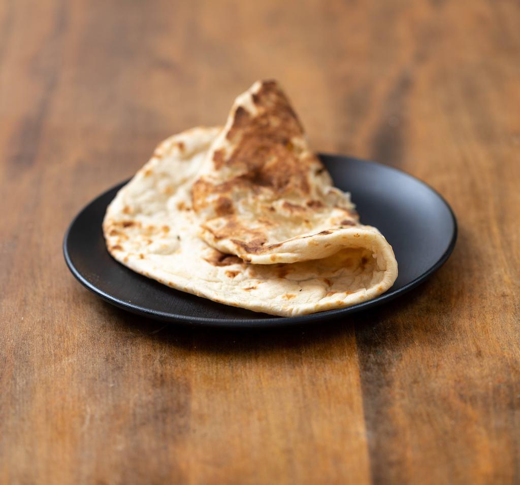 Tandoori Naan · Leavened bread baked in flaming charcoal clay oven. Made with enriched white flour.