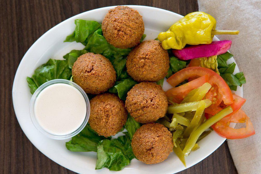 Falafel Plate · Five pieces of crispy falafel (seasoned ground chickpeas and sesame seeds), Greek salad, and hummus with rice.