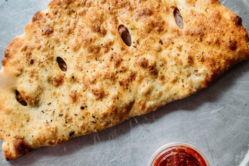 Calzone* · Olive oil, ricotta, mozzarella, and 5 toppings of choice with 1 side of red sauce.

