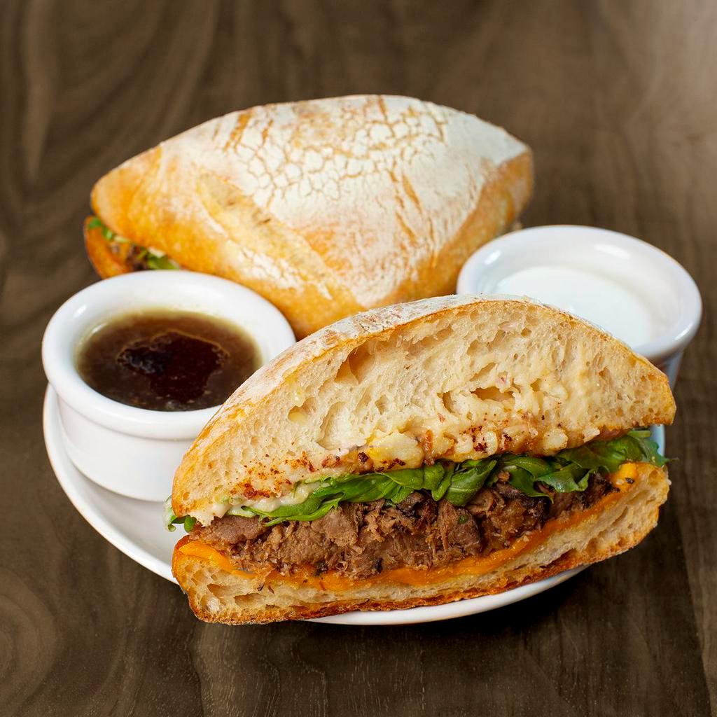 Cheddar Braised Beef Sandwich · braised beef, cheddar, caramelized onion mashed potatoes & organic arugula on a grilled ciabatta roll with au jus, horseradish sauce & served with a side