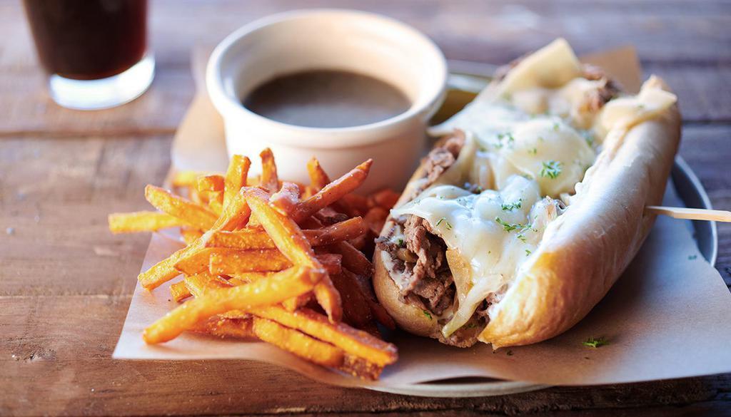 French Dip · Shaved ribeye seasoned and seared, caramelized onions, swiss cheese, garlic aioli, on a lightly toasted hoagie. Served with Guinness infused au jus.