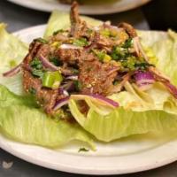16. Crying Tiger Salad · Grill sliced beef tossed in chili pepper-vinaigrette, roasted rice, red onion, green onion, ...