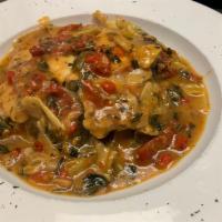 Chicken Carciofini · Pan-seared chicken with spinach, roast peppers, artichokes, and sun-dried tomatoes in white ...