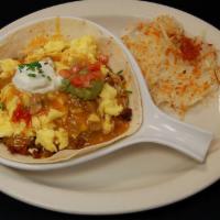 Huevos Rancheros · A flour tortilla layered with refried beans, Jack and cheddar with two eggs any style. Toppe...
