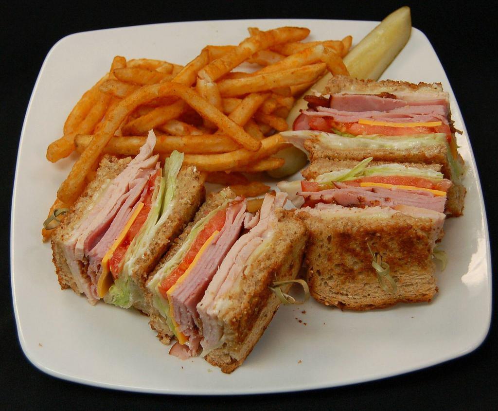 Club Sandwich · Our club sandwich comes piled high with thin sliced smoked turkey, smoked ham, hardwood smoked bacon, mayonnaise, lettuce, tomato with American and Swiss cheese on grilled whole wheat bread.