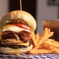 Monster Burger · Beef, chicken, smoked pork chop, cheese, egg, potato sticks, tomato, lettuce. Carne, pollo, ...
