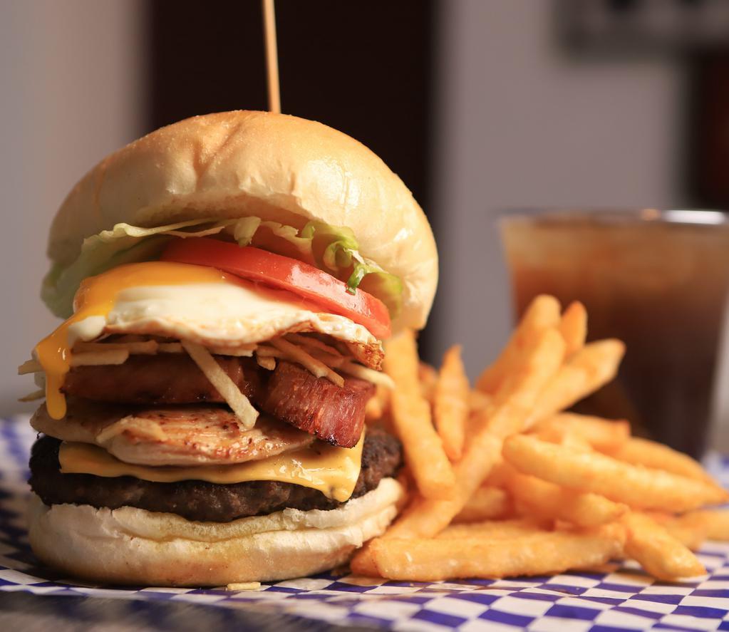 Monster Burger · Beef, chicken, smoked pork chop, cheese, egg, potato sticks, tomato, lettuce. Carne, pollo, chuleta ahumada, queso, huevo, papitas and tomate у lechuga.