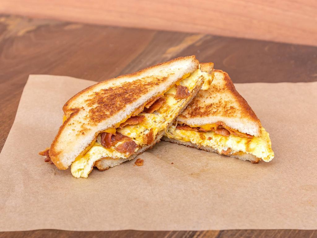 Burnout Breakfast Sandwich · 2 fried eggs, melted cheddar cheese and your choice of bacon, sausage, ham or adobo roasted pork on grilled sourdough.