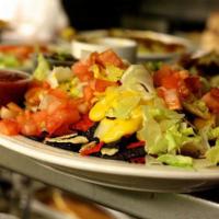 Nachos Supreme ·  Crispy tortillas topped with chili sauce, chopped lettuce, tomato, jalapeno peppers and mel...