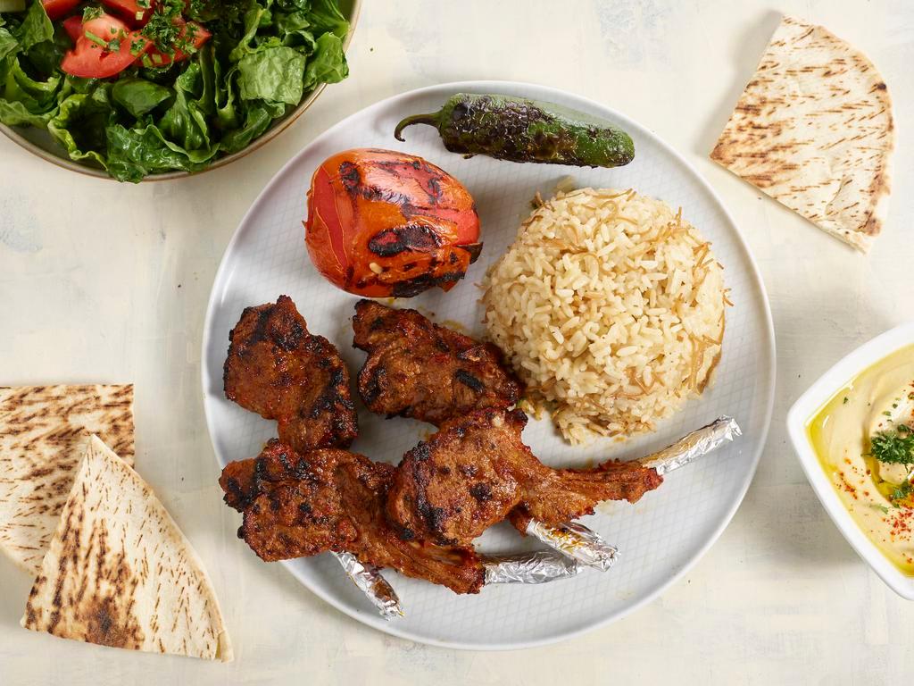 4 pieces Lamb Chops · Grilled lamb chops marinated with spices. Served with rice, hummus, salad and pita.