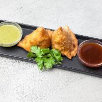 Vegetable Samosa · Crispy fried turnover deliciously filled with mildly spiced potatoes and green peas.