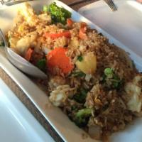 64. Thai Time Fried Rice · Thai style fried rice with shrimp and calamari, onion, pineapple, tomato, broccoli, and carr...