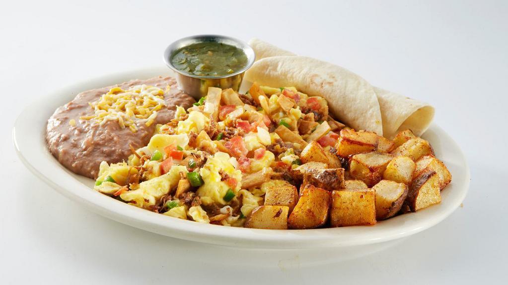 Chicken Chilaquiles · 2 scrambled eggs, shredded chicken, tortillas strips, shredded cheese, and pico de gallo. Served with refried beans, Latin-fried potatoes, 2 flour tortillas, and salsa verde.
