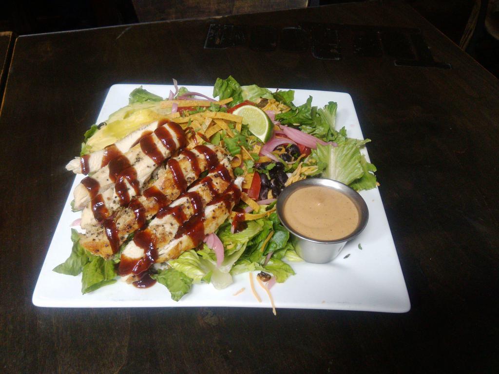 BBQ Chicken Salad · Grilled free range chicken glazed with hickory BBQ sauce, Romaine, black beans, cheddar, corn, tomatoes, avocado, sauteed red onions, tortilla strips, cilantro and BBQ ranch dressing.