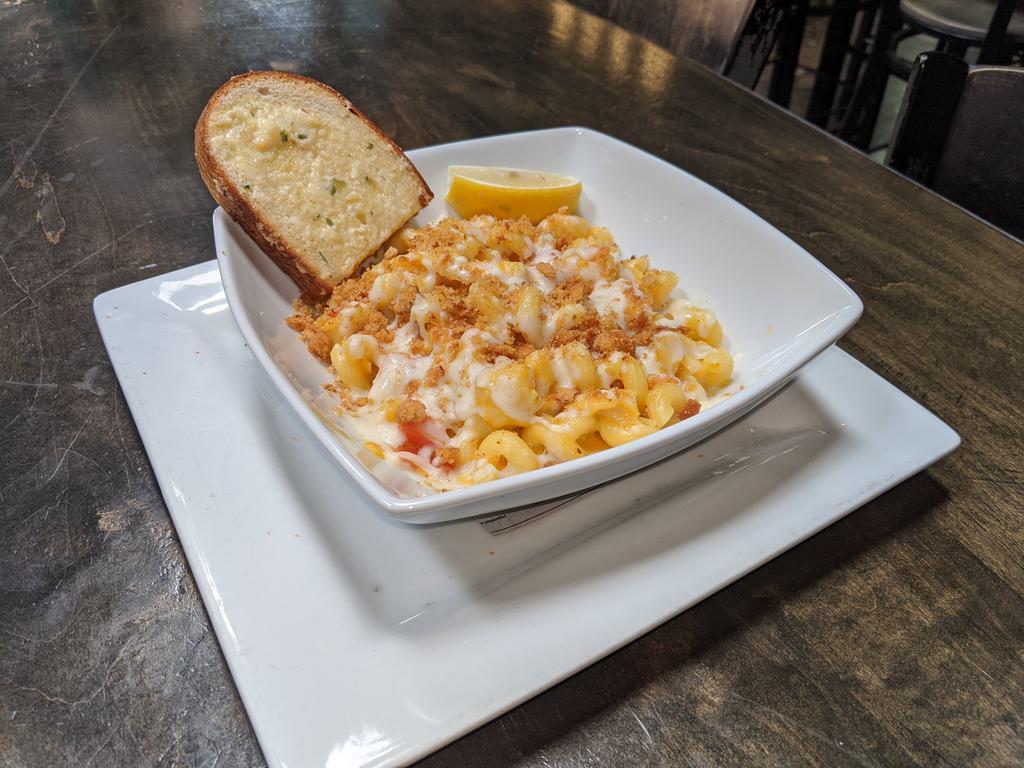 Lobster Mac and Cheese · Sauteed garlic, lobster, chopped tomatoes, brandy cream sauce and cheese topped with bread crumbs. Served with garlic bread.