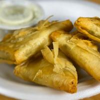 Spanakopita · 4 pieces of spinach-cheese pie, made from a special mix of spinach and feta cheese with seve...