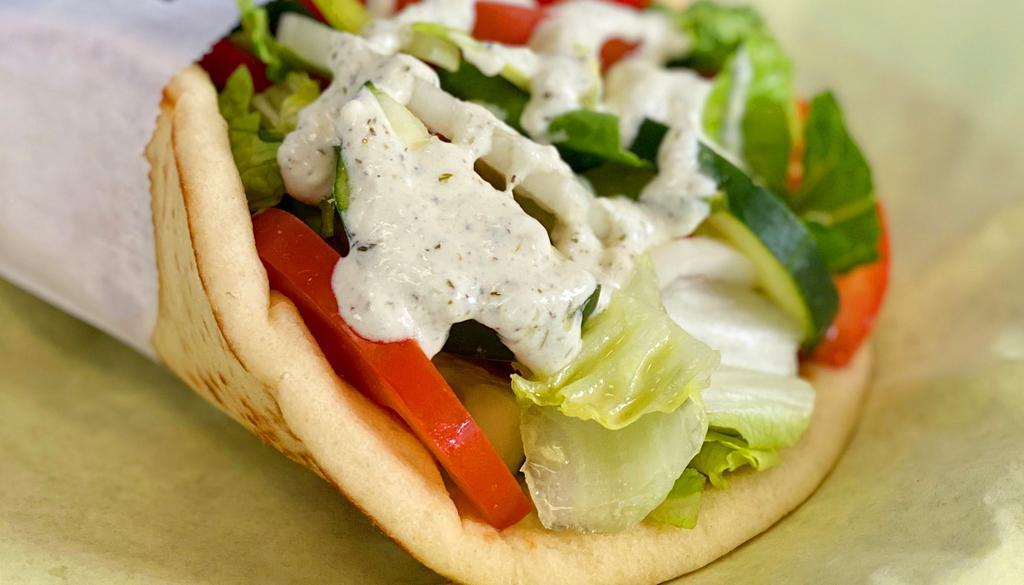 Veggie Pita · Romaine lettuce, cucumber, tomatoes, green peppers, red peppers, hummus, and tzatziki sauce.