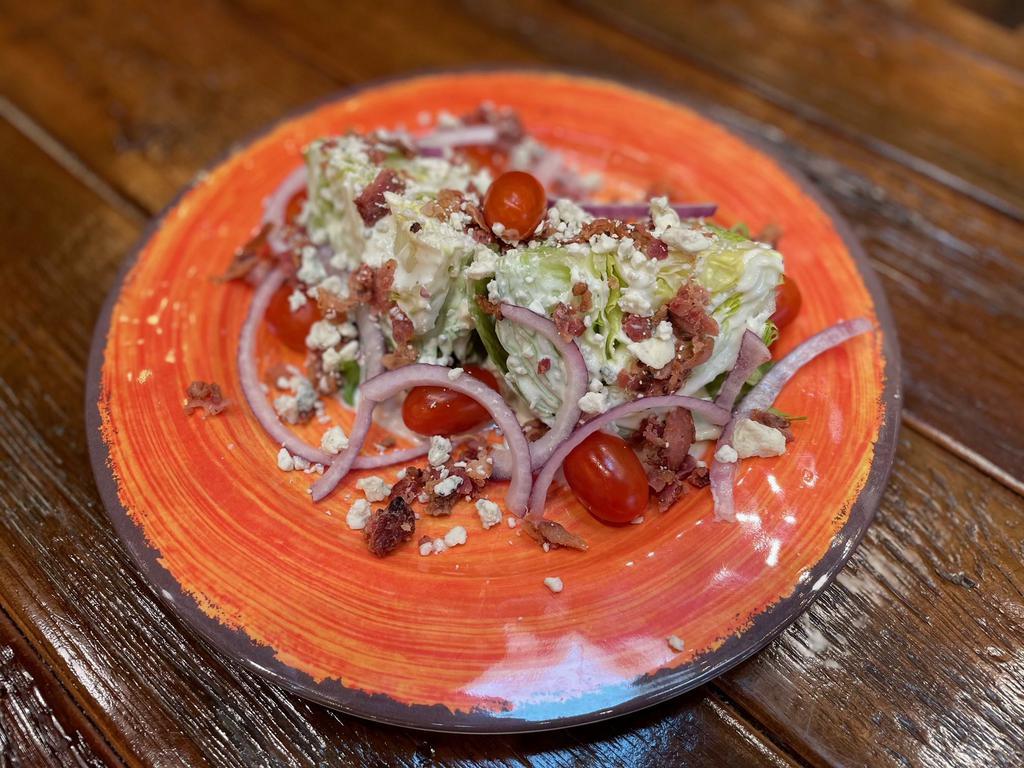 Wedge Salad · 1/2 head of tender, crisp baby iceberg lettuce, topped with sliced red onion, fresh grape tomatoes, tasty bacon bits, and blue cheese crumbles. Served with your choice of House Ranch or Blue Cheese Dressing.