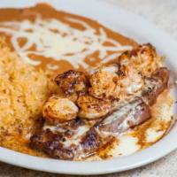 Steak Vallarta · 12 oz. rib-eye steak topped with shrimp and nacho cheese. Served with rice, beans, guacamole...