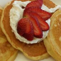 Buttermilk Pancakes · Three large homemade buttermilk pancakes, topped with powdered sugar and a strawberry