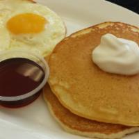 2 Eggs and 2 Pancakes · Two homemade buttermilk pancakes topped with powdered sugar and a strawberry, served with tw...