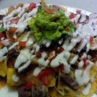 Super Nachos · Home made tortillas chips, served with beans, choice of meat, cheese, pico de gallo, sour cr...