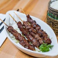 11. Ping Seen (Lao Beef Skewer) · Laotian style of marinated beef cut into pieces, skewered on bamboo and grilled. Four skewer...