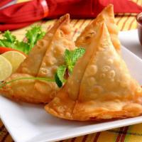 Vegetable Samosa · Triangular pies stuffed with potatoes and peas and delicately tempered with spices and herbs.